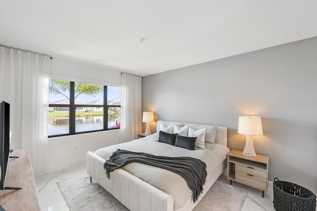 bedroom featuring marble finish floor and baseboards