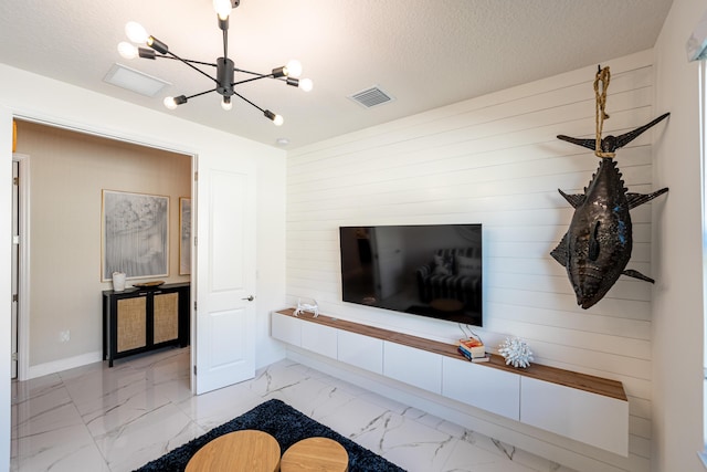 living room featuring a textured ceiling, visible vents, marble finish floor, and a chandelier