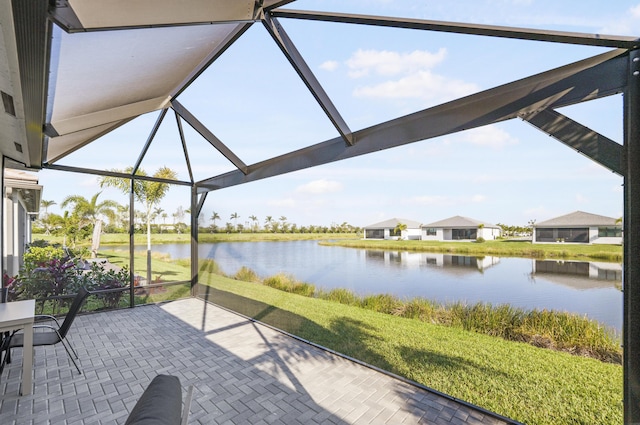 view of patio featuring glass enclosure and a water view