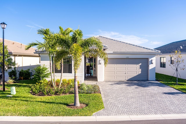 ranch-style house featuring a tiled roof, decorative driveway, a garage, and stucco siding