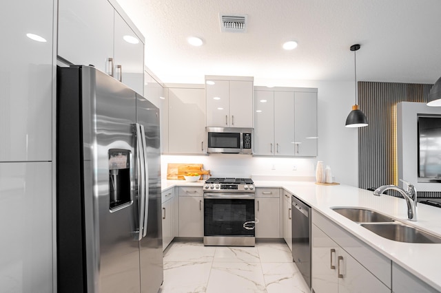 kitchen featuring visible vents, pendant lighting, marble finish floor, stainless steel appliances, and a sink