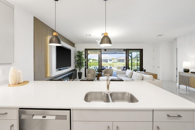 kitchen featuring light countertops, white cabinets, marble finish floor, stainless steel dishwasher, and open floor plan