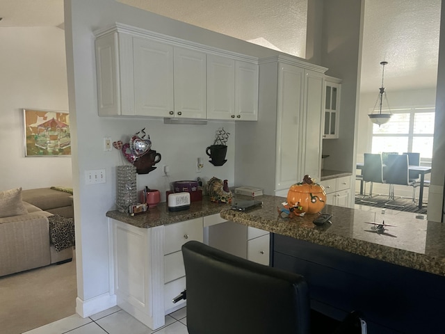 kitchen with white cabinetry, dark stone counters, and light tile patterned flooring