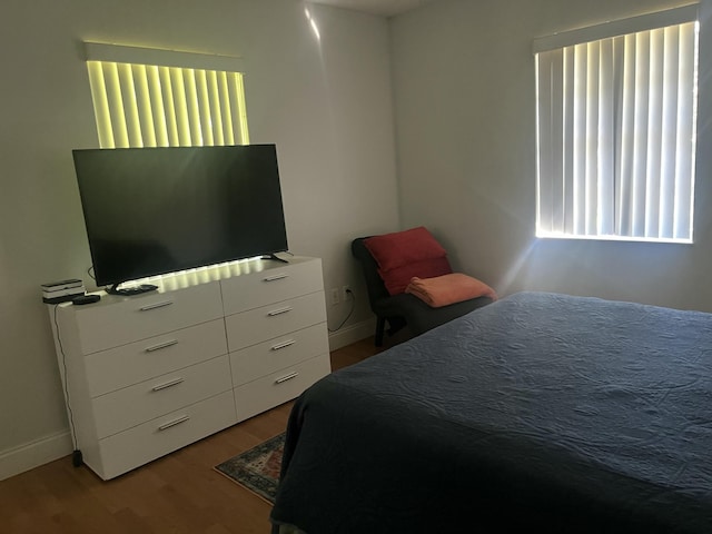 bedroom with baseboards and wood finished floors