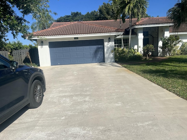 view of front of property with stucco siding, a tile roof, concrete driveway, a front yard, and an attached garage