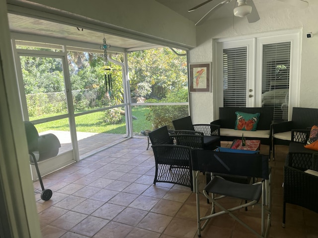 sunroom / solarium featuring lofted ceiling, a healthy amount of sunlight, and a ceiling fan