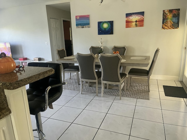 dining space featuring light tile patterned floors and baseboards