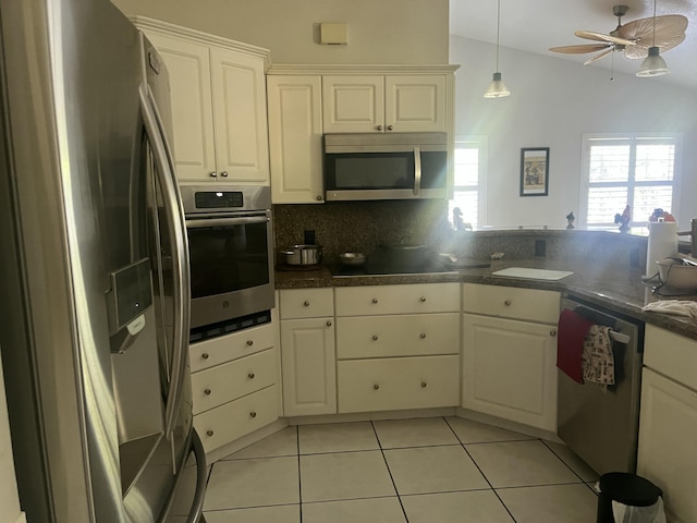 kitchen featuring light tile patterned floors, ceiling fan, stainless steel appliances, white cabinetry, and backsplash