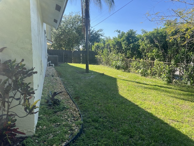 view of yard with central AC unit and a fenced backyard