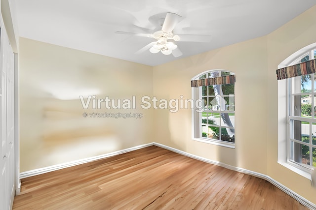 empty room featuring a ceiling fan, wood finished floors, and baseboards