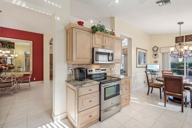 kitchen with light tile patterned floors, visible vents, stainless steel appliances, decorative backsplash, and a chandelier