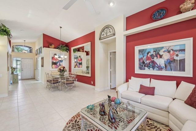 living room featuring light tile patterned floors, baseboards, ceiling fan, and vaulted ceiling