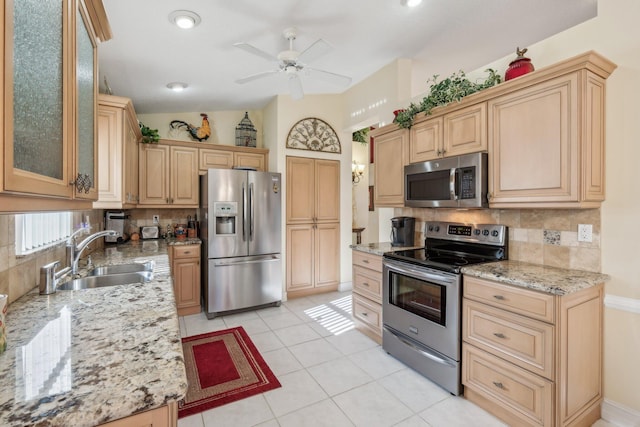 kitchen featuring a sink, tasteful backsplash, appliances with stainless steel finishes, and a ceiling fan