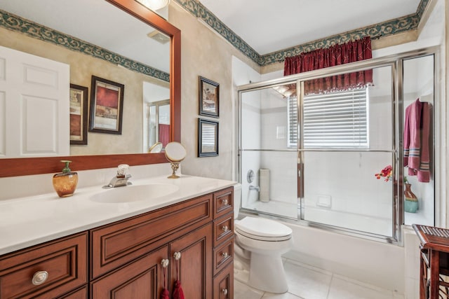 full bath featuring tile patterned floors, visible vents, toilet, bath / shower combo with glass door, and vanity