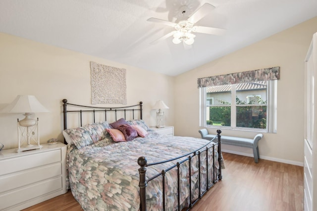 bedroom with ceiling fan, baseboards, lofted ceiling, and wood finished floors