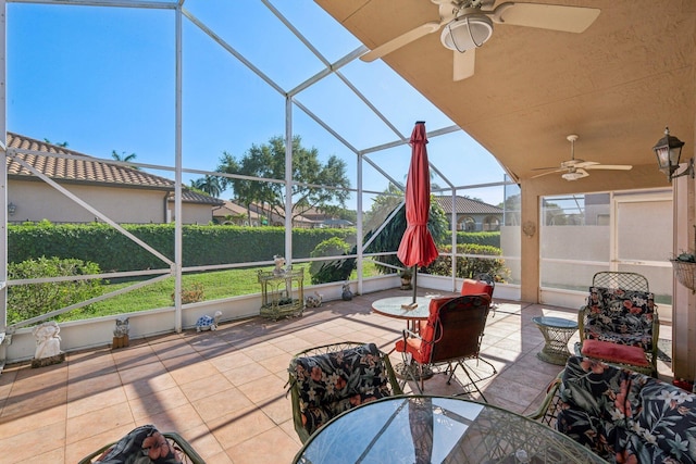 view of patio with a lanai, outdoor dining space, and ceiling fan