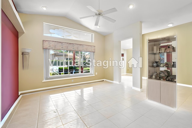 spare room featuring light tile patterned flooring, baseboards, a ceiling fan, and vaulted ceiling