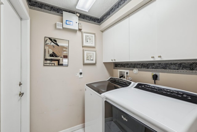 laundry area with cabinet space, a textured ceiling, and independent washer and dryer