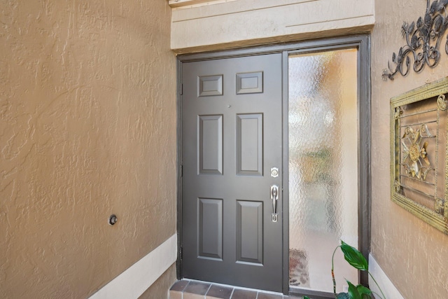 property entrance with stucco siding
