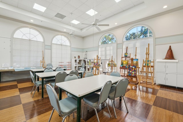 dining space with hardwood / wood-style flooring, a tray ceiling, and ceiling fan