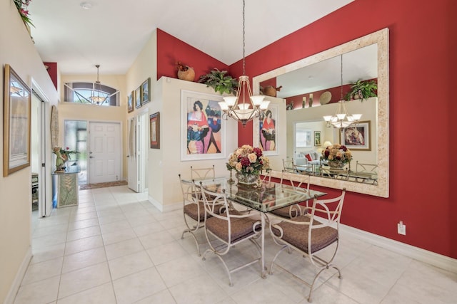 dining room with baseboards, a chandelier, a towering ceiling, and tile patterned flooring