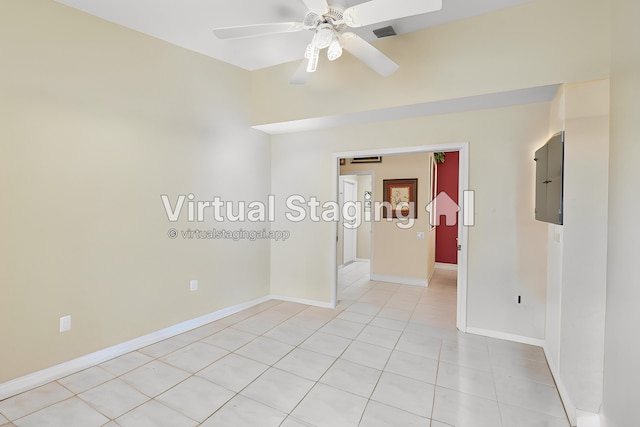 spare room with visible vents, baseboards, electric panel, light tile patterned floors, and a ceiling fan
