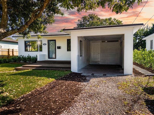 view of front of house featuring a yard, fence, and stucco siding