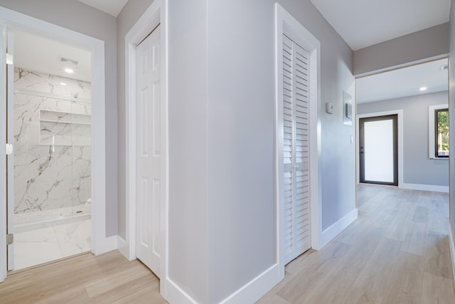 corridor featuring baseboards and light wood-style floors