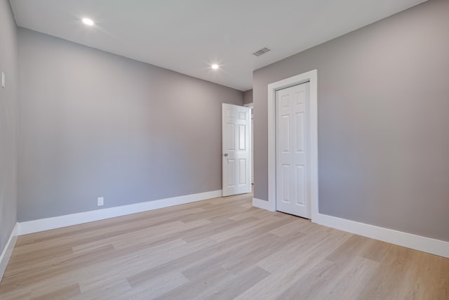 empty room with recessed lighting, baseboards, visible vents, and light wood finished floors