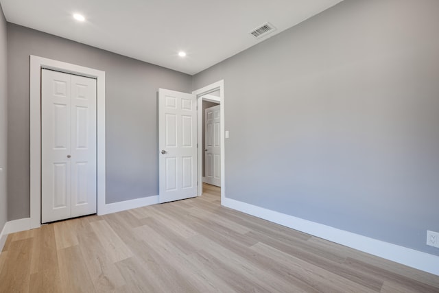 unfurnished bedroom featuring visible vents, baseboards, and light wood-style flooring