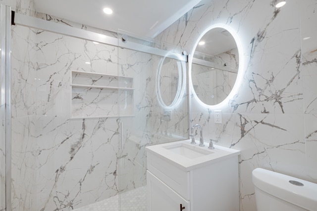 bathroom featuring a marble finish shower, toilet, stone wall, and vanity