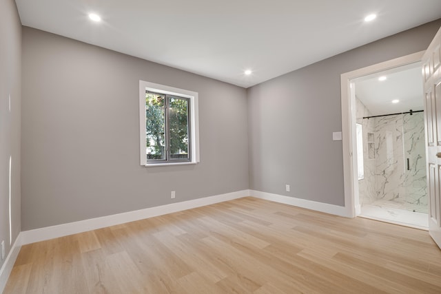 spare room featuring light wood finished floors, recessed lighting, and baseboards