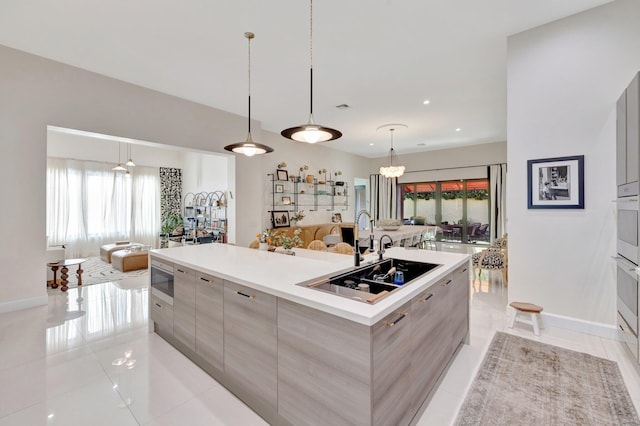 kitchen with a sink, stainless steel microwave, modern cabinets, and open floor plan