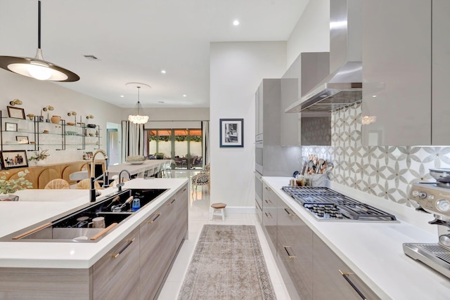 kitchen with visible vents, modern cabinets, wall chimney range hood, and stainless steel gas stovetop