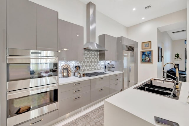 kitchen with visible vents, gray cabinets, stainless steel appliances, wall chimney exhaust hood, and modern cabinets