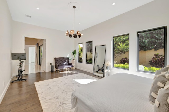 bedroom with visible vents, baseboards, recessed lighting, wood finished floors, and a notable chandelier