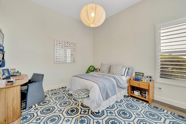 bedroom featuring wood finished floors and baseboards