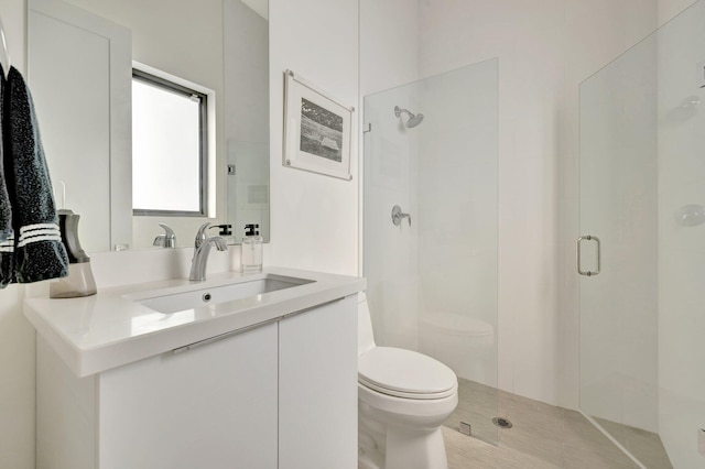 bathroom featuring a stall shower, toilet, and vanity