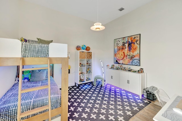 bedroom featuring visible vents and wood finished floors