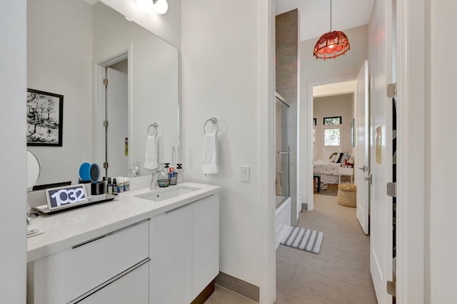 ensuite bathroom with connected bathroom, vanity, and bath / shower combo with glass door