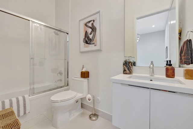 full bath with vanity, baseboards, enclosed tub / shower combo, tile patterned flooring, and toilet