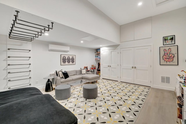 living room with visible vents, baseboards, a wall mounted air conditioner, recessed lighting, and a towering ceiling