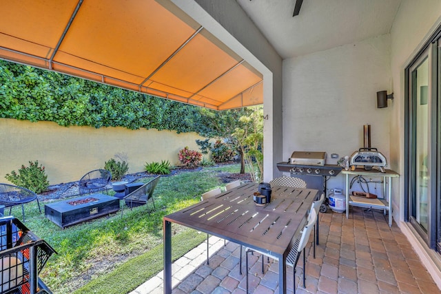 view of patio / terrace featuring outdoor dining area, a fire pit, and grilling area