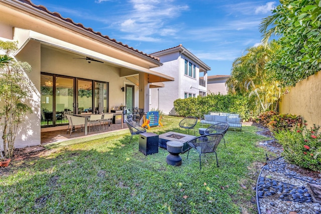 view of yard featuring a ceiling fan, a patio area, and a fire pit