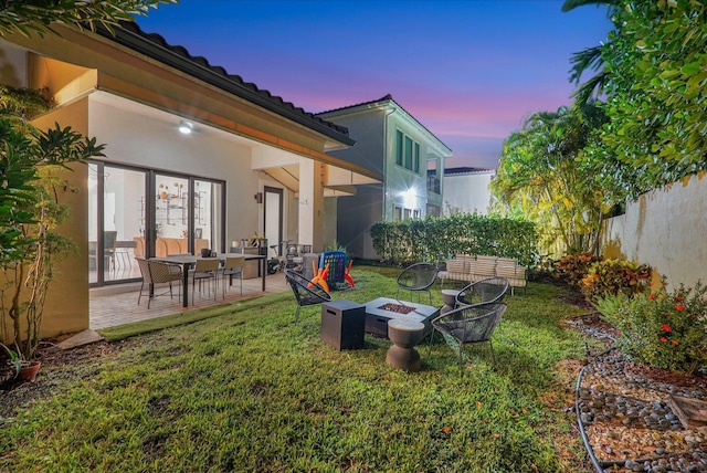 view of yard with fence, a fire pit, and a patio area