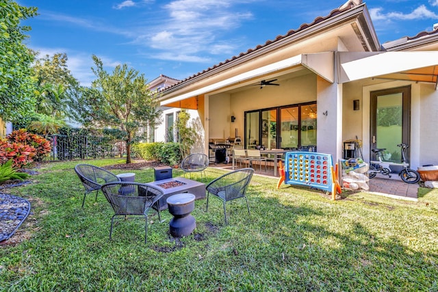 view of yard featuring a patio, fence, ceiling fan, and an outdoor fire pit