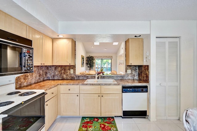 kitchen with white appliances, light brown cabinets, light tile patterned flooring, a sink, and backsplash