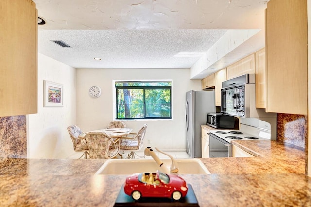 kitchen with light brown cabinets, light countertops, a textured ceiling, white electric range, and a sink