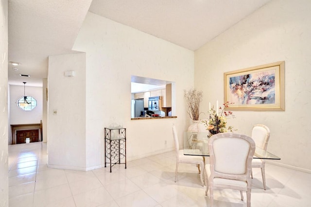 dining room featuring tile patterned flooring, baseboards, and lofted ceiling