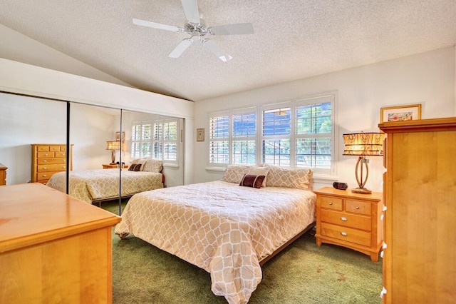 carpeted bedroom featuring lofted ceiling, a ceiling fan, a closet, and a textured ceiling